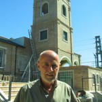 El Padre Hernán con la iglesia de fondo